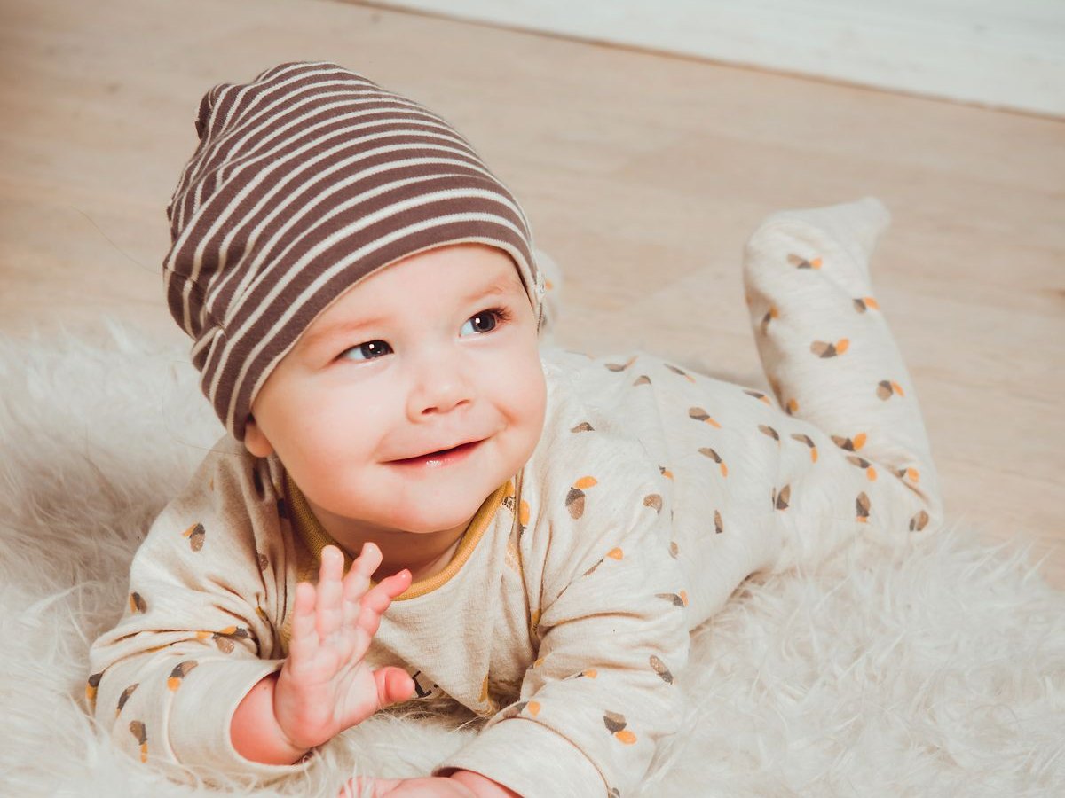 Lachende baby op een wit kleed