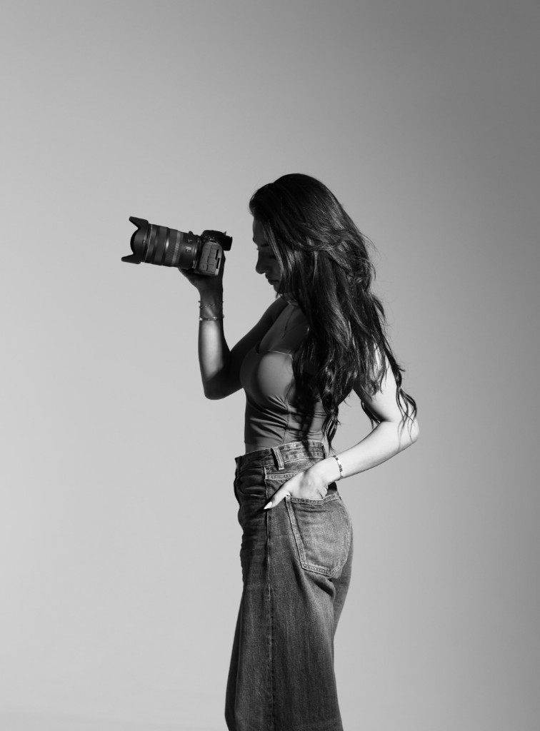 Ninevah Alkan in de studio met camera, portret in zwart en wit