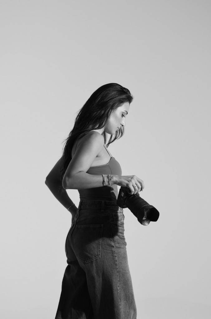Ninevah Alkan met camera in profiel in de studio, zwart-wit