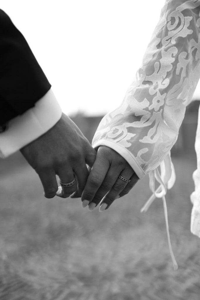 Bruid en bruidegom hand in hand, zwart-wit