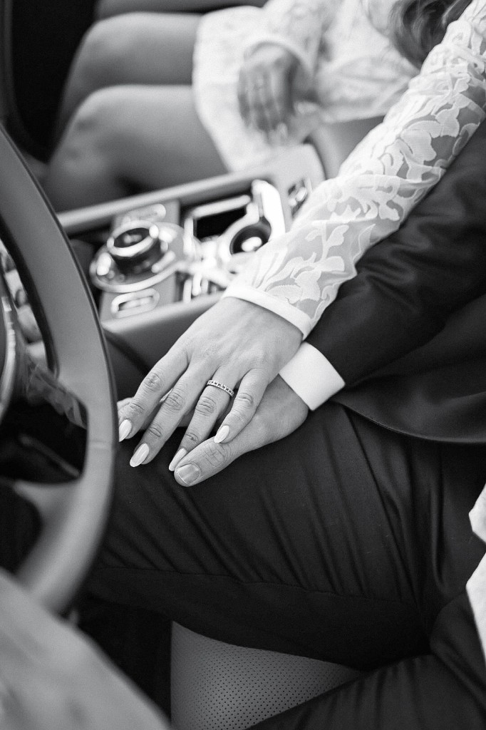 Bruidspaar handen in de auto, zwart-wit