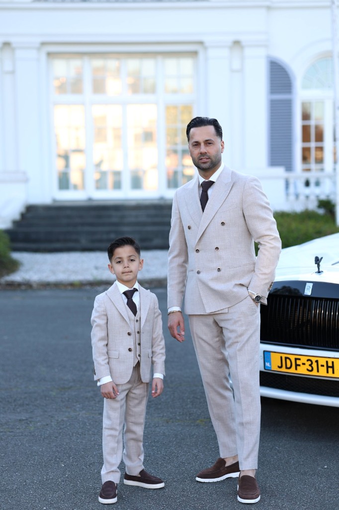 Vader en zoon in beige pakken bij Rolls-Royce